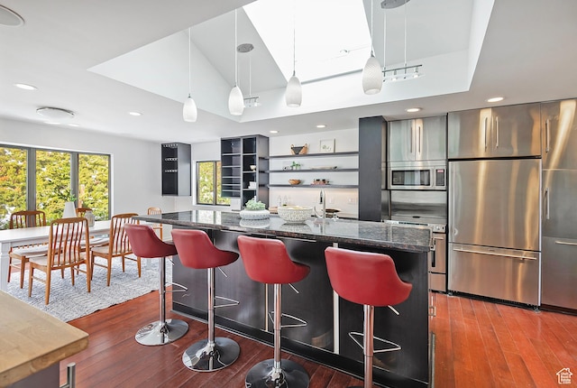 579 E 13th Ave, Salt Lake City, UT 84103 - kitchen featuring stainless steel appliances, a kitchen bar, open shelves, and dark stone counters