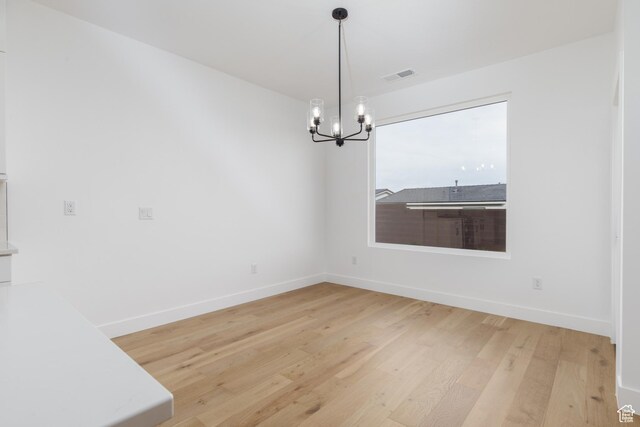 4153 El Capitan Way, St George, UT 84790 - unfurnished dining area featuring visible vents, baseboards, light wood-type flooring, and a chandelier