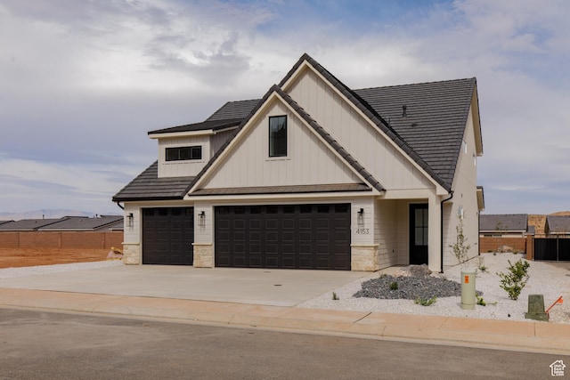 4153 El Capitan Way, St George, UT 84790 - modern farmhouse style home with board and batten siding, a garage, fence, stone siding, and concrete driveway
