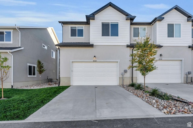 view of front of house with a garage, stucco siding, and concrete driveway