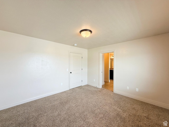 141 E 620 S, Smithfield, UT 84335 - unfurnished bedroom with baseboards, light colored carpet, and a textured ceiling