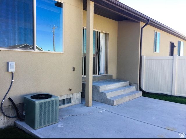 141 E 620 S, Smithfield, UT 84335 - view of exterior entry with central air condition unit, a patio, stucco siding, and fence