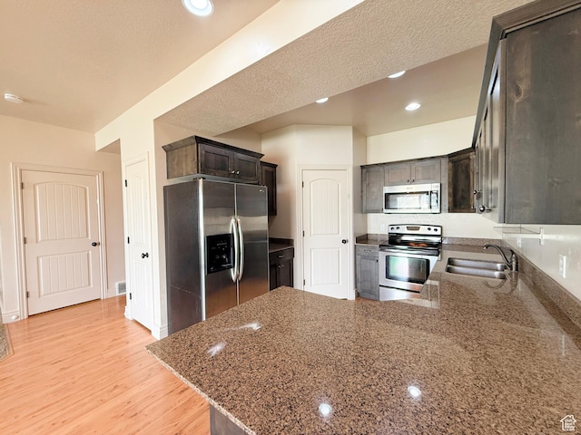 141 E 620 S, Smithfield, UT 84335 - kitchen with a sink, appliances with stainless steel finishes, a peninsula, light wood-style floors, and stone countertops