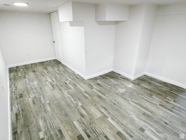 finished basement featuring wood finished floors and baseboards