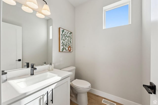2612 S 8550 W, Magna, UT 84044 - bathroom featuring vanity, baseboards, toilet, visible vents, and wood finished floors