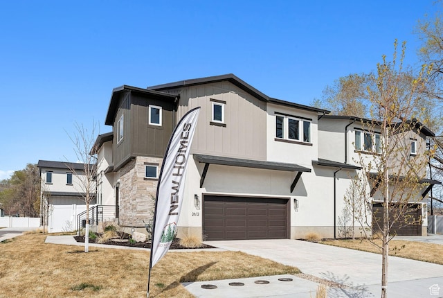 2612 S 8550 W, Magna, UT 84044 - view of front of house featuring stone siding, concrete driveway, a garage, and fence