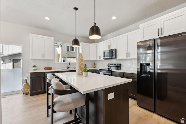 2612 S 8550 W, Magna, UT 84044 - kitchen with decorative backsplash, light countertops, black range with electric stovetop, and stainless steel fridge