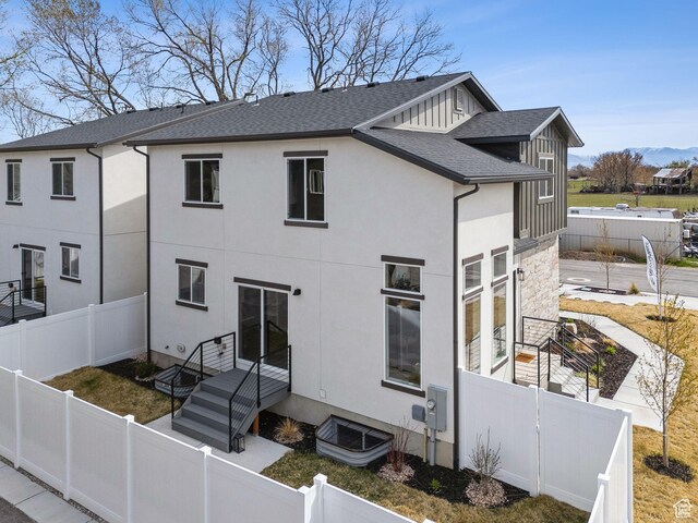 2612 S 8550 W, Magna, UT 84044 - back of property with a shingled roof, a fenced front yard, and stucco siding
