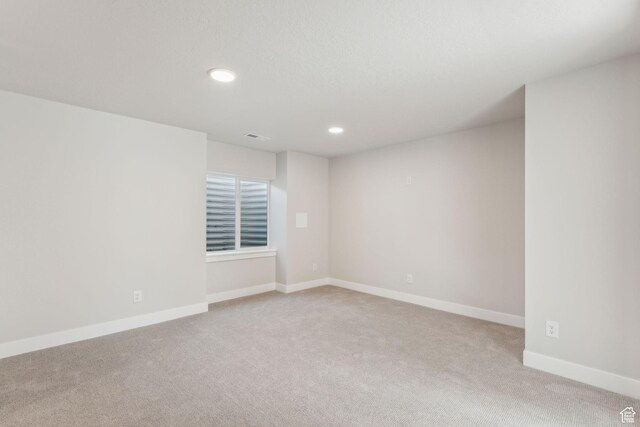 empty room featuring visible vents, baseboards, recessed lighting, and light colored carpet