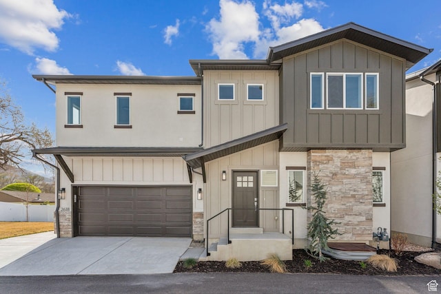 view of front facade featuring board and batten siding, stone siding, a garage, and concrete driveway