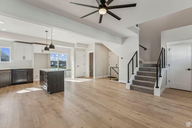 interior space featuring tasteful backsplash, a ceiling fan, decorative light fixtures, light wood-style floors, and dishwasher
