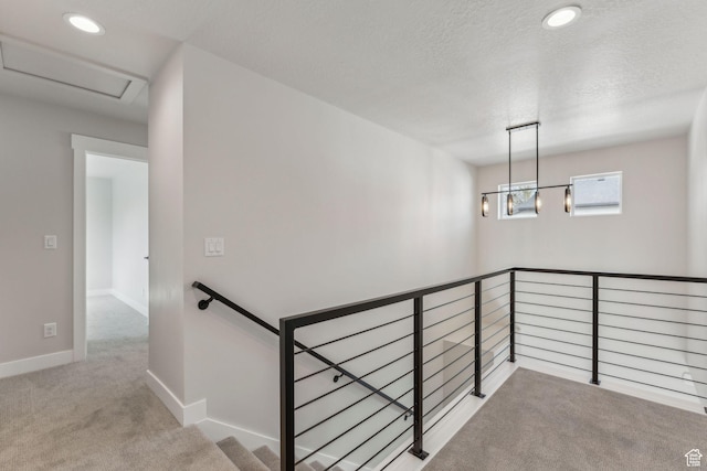 stairway featuring baseboards, recessed lighting, a textured ceiling, attic access, and carpet floors