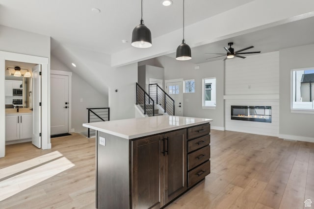kitchen featuring hanging light fixtures, light wood-type flooring, and a wealth of natural light