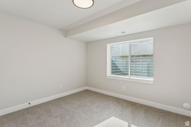 carpeted empty room with visible vents and baseboards