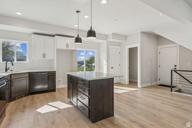 kitchen featuring tasteful backsplash, light wood-style flooring, white cabinetry, stainless steel appliances, and a sink