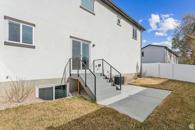 back of property featuring a lawn, fence, cooling unit, a patio, and stucco siding