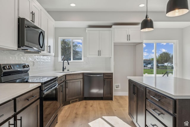 kitchen with dishwasher, a sink, dark brown cabinets, white cabinetry, and black range with electric stovetop