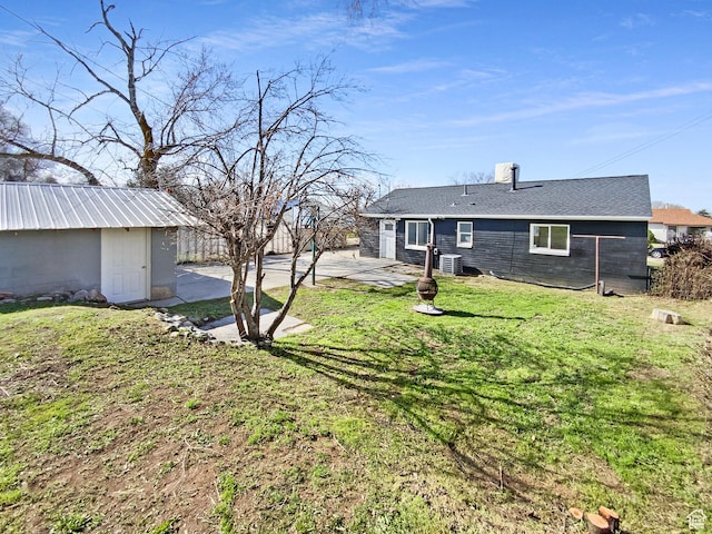 view of yard featuring a shed, a patio, an outdoor structure, and fence