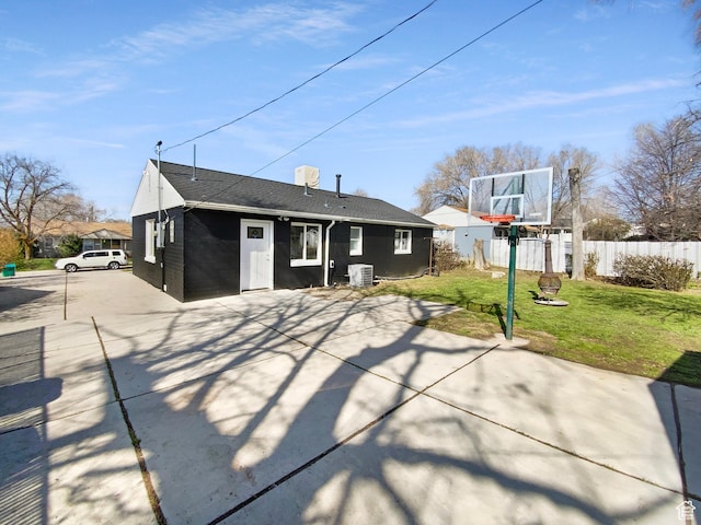 back of house featuring central AC unit, fence, and a lawn