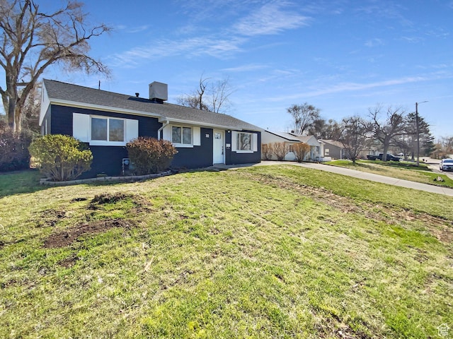 single story home featuring a chimney, concrete driveway, and a front lawn