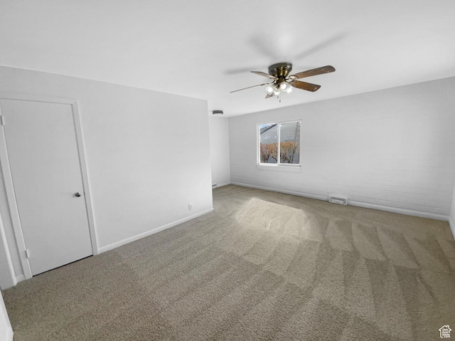 empty room with visible vents, ceiling fan, carpet flooring, and baseboards