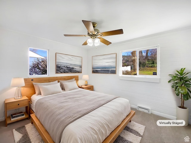 bedroom with ornamental molding, visible vents, ceiling fan, and carpet