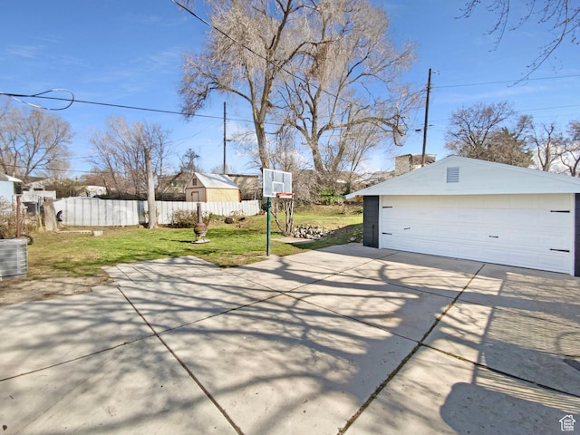 view of patio / terrace with a garage, an outdoor structure, and fence
