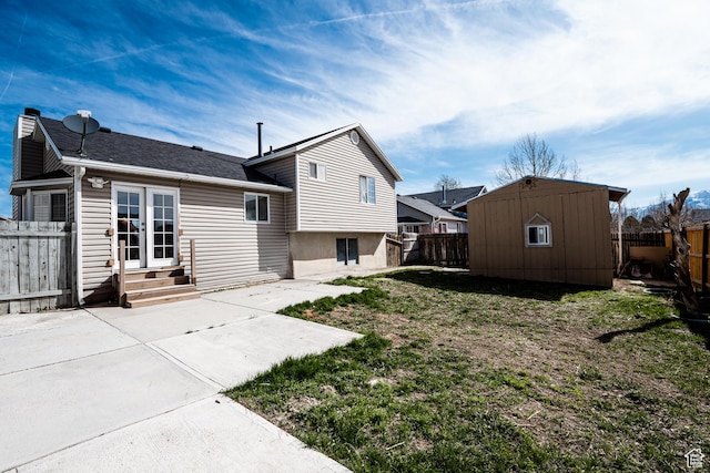 rear view of property featuring a patio, a fenced backyard, entry steps, and an outdoor structure
