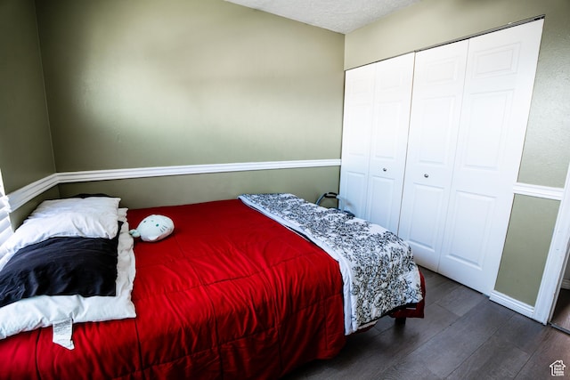 bedroom featuring dark wood-style flooring, a closet, and a textured ceiling