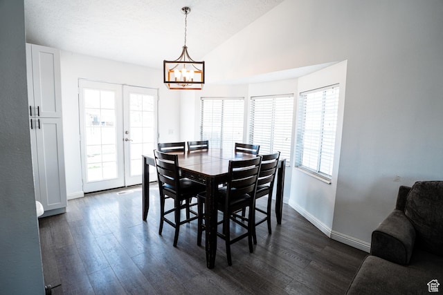 dining space featuring dark wood-style flooring, plenty of natural light, a chandelier, and vaulted ceiling