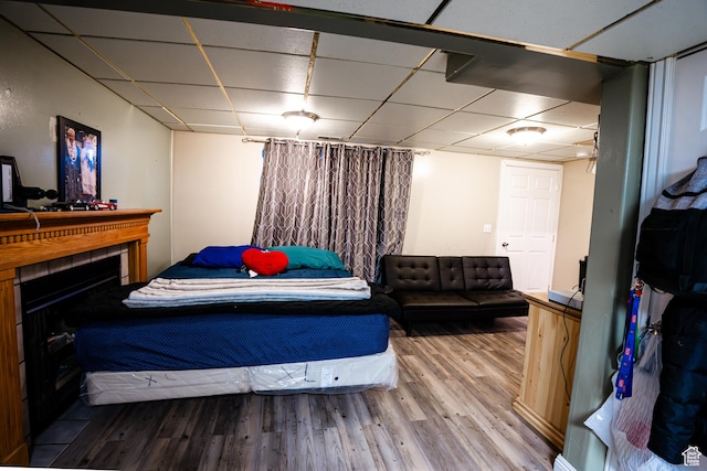 bedroom featuring a drop ceiling and wood finished floors