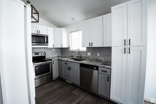 kitchen featuring a sink, gray cabinets, decorative backsplash, and stainless steel appliances