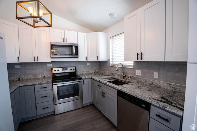 4129 W Misty Dr S, Taylorsville, UT 84129 - kitchen featuring stainless steel appliances, a sink, lofted ceiling, decorative backsplash, and light stone countertops