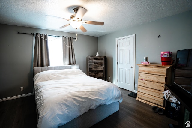 bedroom featuring a ceiling fan, a textured ceiling, baseboards, and dark wood-style floors