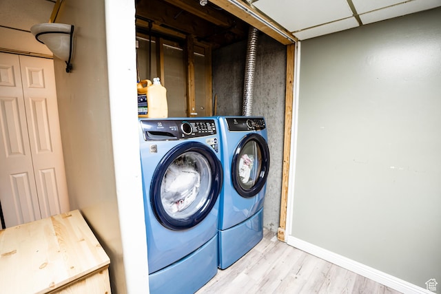 laundry area featuring independent washer and dryer, wood finished floors, and baseboards