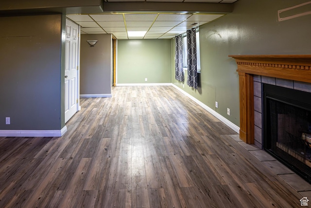 4129 W Misty Dr S, Taylorsville, UT 84129 - unfurnished living room featuring a drop ceiling, wood finished floors, a tiled fireplace, and baseboards