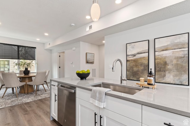 kitchen with visible vents, a sink, white cabinetry, dark wood-type flooring, and stainless steel dishwasher