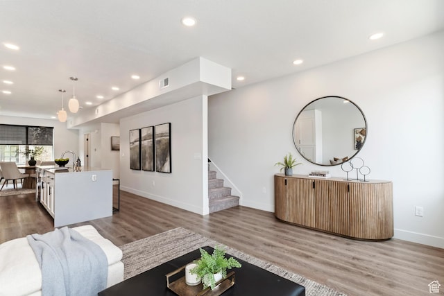 living room with recessed lighting, baseboards, and wood finished floors