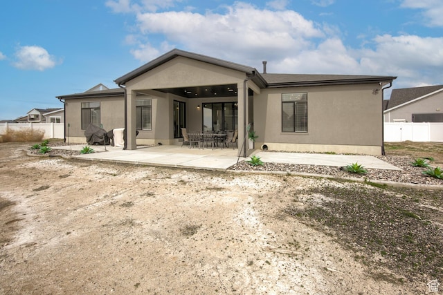 2543 W 3350 S Unit 210, Syracuse, UT 84075 - rear view of property featuring stucco siding, fence, and a patio area