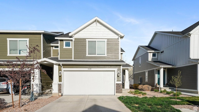 view of front of house featuring an attached garage, driveway, and stone siding