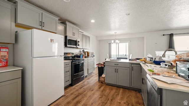 448 S Pegasus Way, Saratoga Springs, UT 84045 - kitchen featuring an inviting chandelier, light countertops, wood finished floors, stainless steel appliances, and gray cabinets