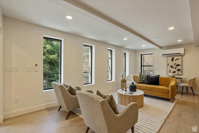5290 E Emigration Canyon Rd, Salt Lake City, UT 84108 - living room featuring a textured ceiling, a wall mounted AC, light wood finished floors, and baseboards