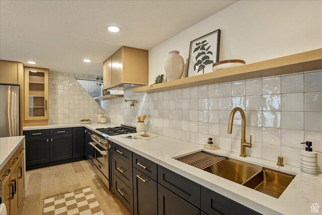 5290 E Emigration Canyon Rd, Salt Lake City, UT 84108 - kitchen with light wood-type flooring, light stone counters, open shelves, stainless steel appliances, and a sink