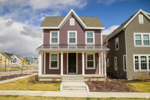 view of front of house with a porch, metal roof, a standing seam roof, and roof with shingles