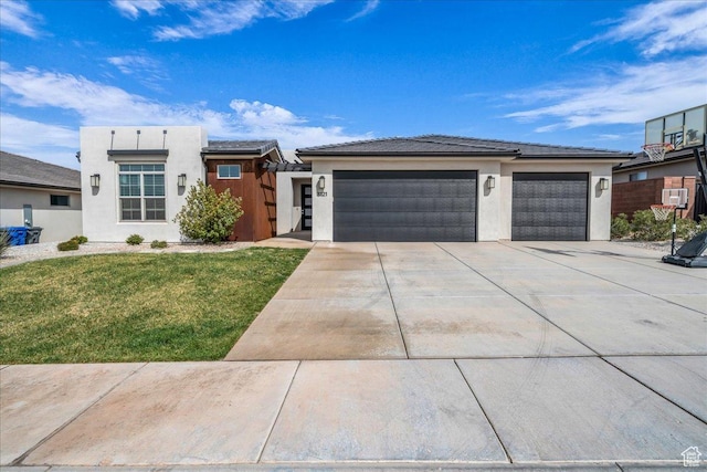 view of front of home featuring an attached garage, fence, concrete driveway, a front lawn, and stucco siding