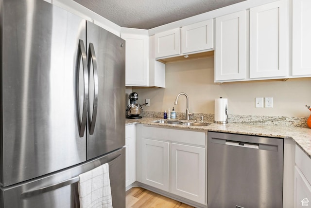 473 S 2400 W Unit 3, Springville, UT 84663 - kitchen with light wood-style floors, white cabinets, light stone counters, a sink, and stainless steel appliances