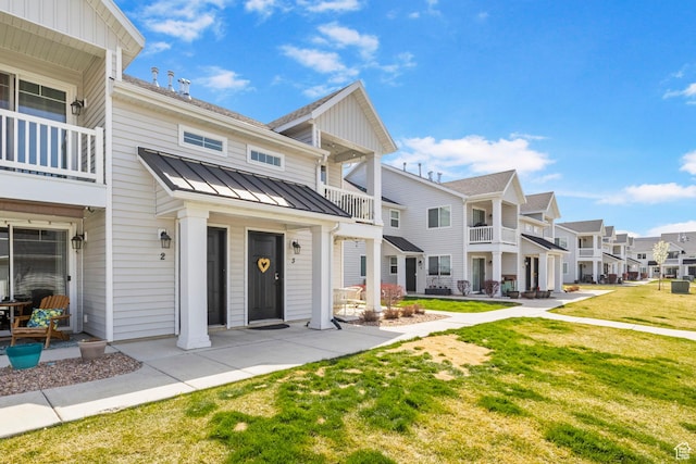 473 S 2400 W Unit 3, Springville, UT 84663 - view of front of house featuring a standing seam roof, metal roof, a front yard, a balcony, and a residential view