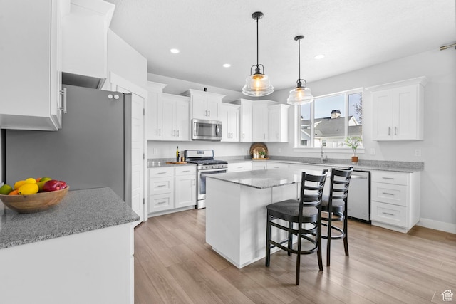 516 W 1000 N, Mapleton, UT 84664 - kitchen with white cabinets, a center island, light wood-type flooring, and stainless steel appliances