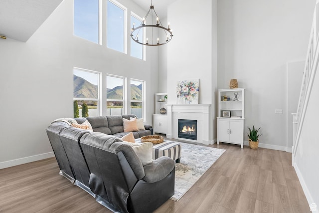 516 W 1000 N, Mapleton, UT 84664 - living area with a glass covered fireplace, baseboards, a notable chandelier, and wood finished floors