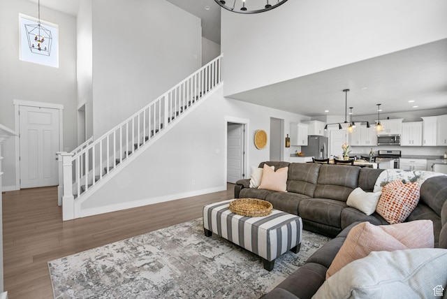 516 W 1000 N, Mapleton, UT 84664 - living area with baseboards, stairway, an inviting chandelier, and wood finished floors